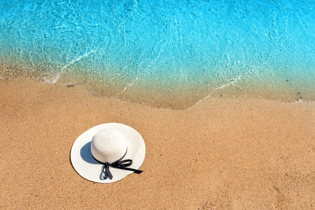 white-woman-straw-hat-laying-tropical-sand-beach-with-blue-vibrant-ocean-water-background-sunny-summer-day-vacations-destination-travel-concept_127089-9158